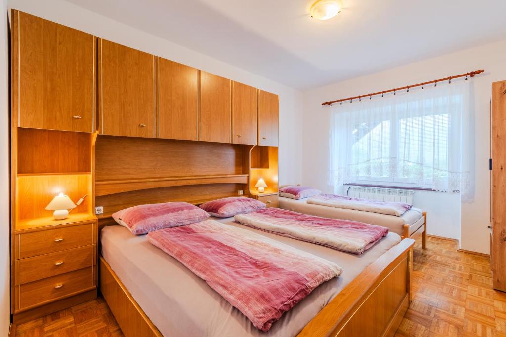 two beds in a bedroom with wooden cabinets at Penzion Hosnar in Bovec