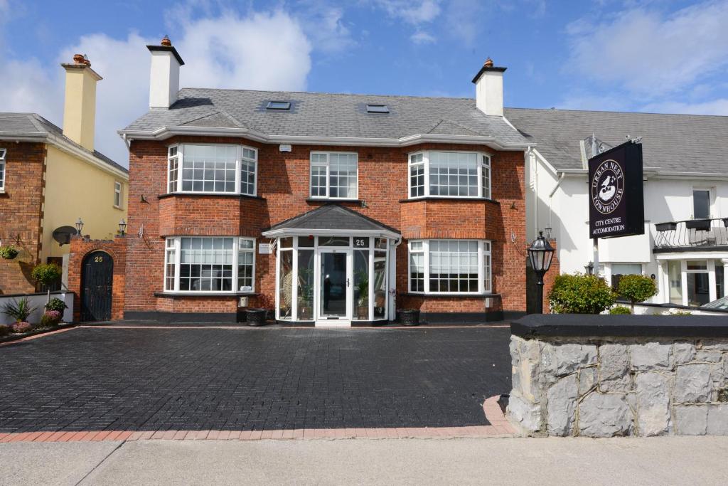 a red brick building with a sign in front of it at Urban Nest Townhouse in Galway