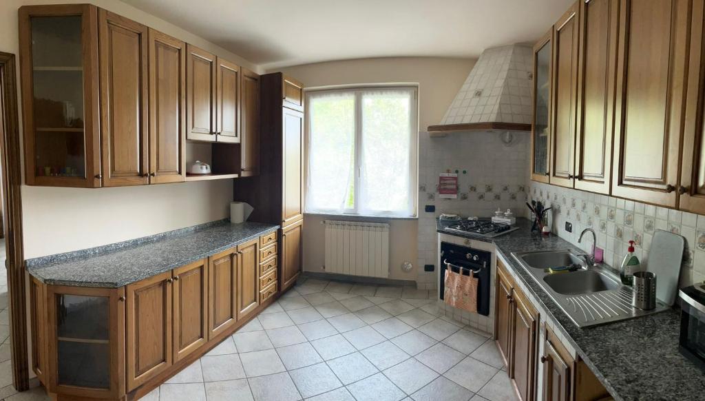 una cocina con armarios de madera y fregadero en Casa Perin, en Vezzano Ligure