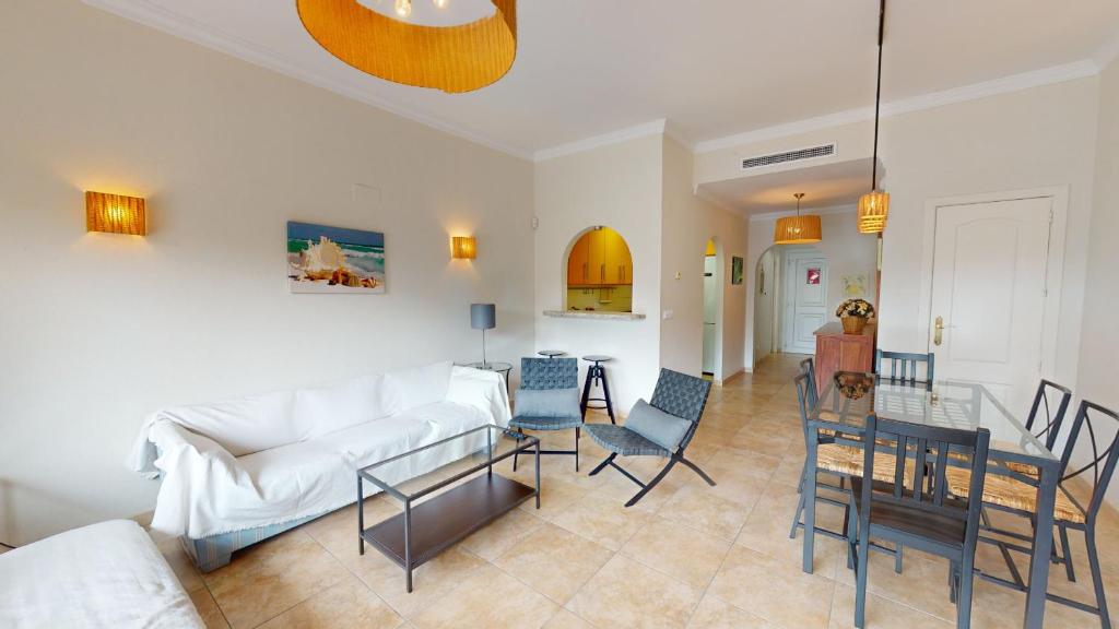 ein Wohnzimmer mit einem weißen Sofa und einem Tisch in der Unterkunft Palmera by Oliva Nova in Oliva