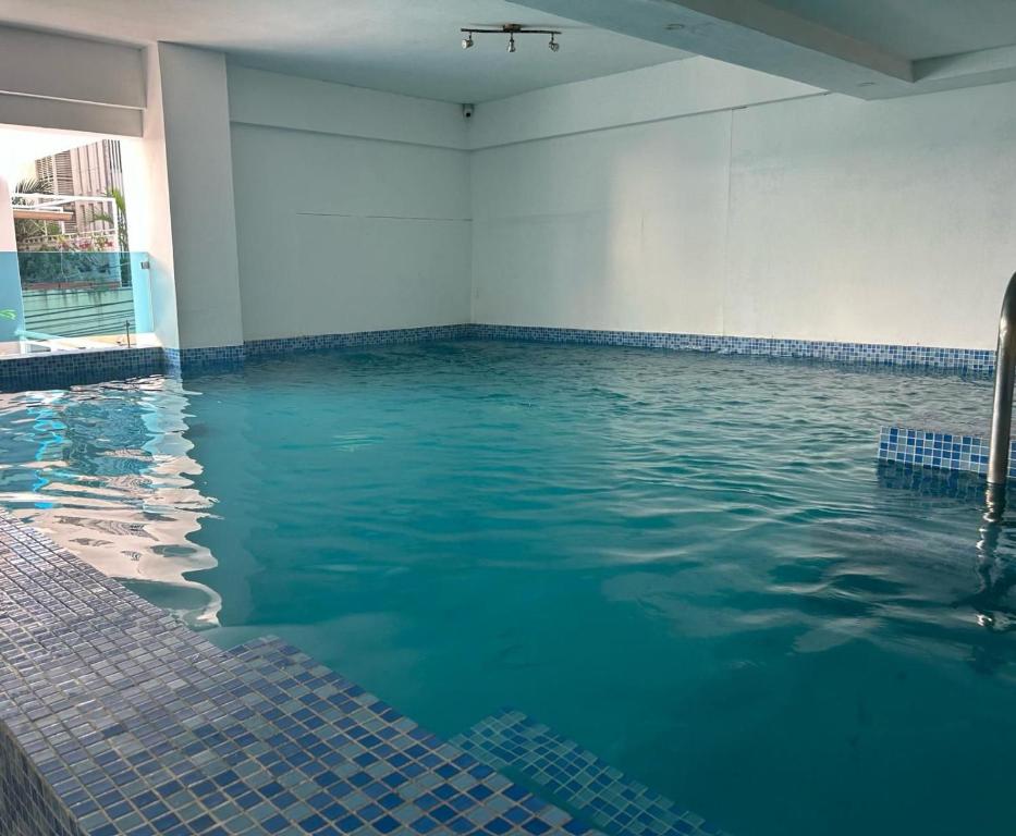 ein Pool mit blauem Wasser in einem Gebäude in der Unterkunft Ejecutivo penthouse en santo domingo in Santo Domingo