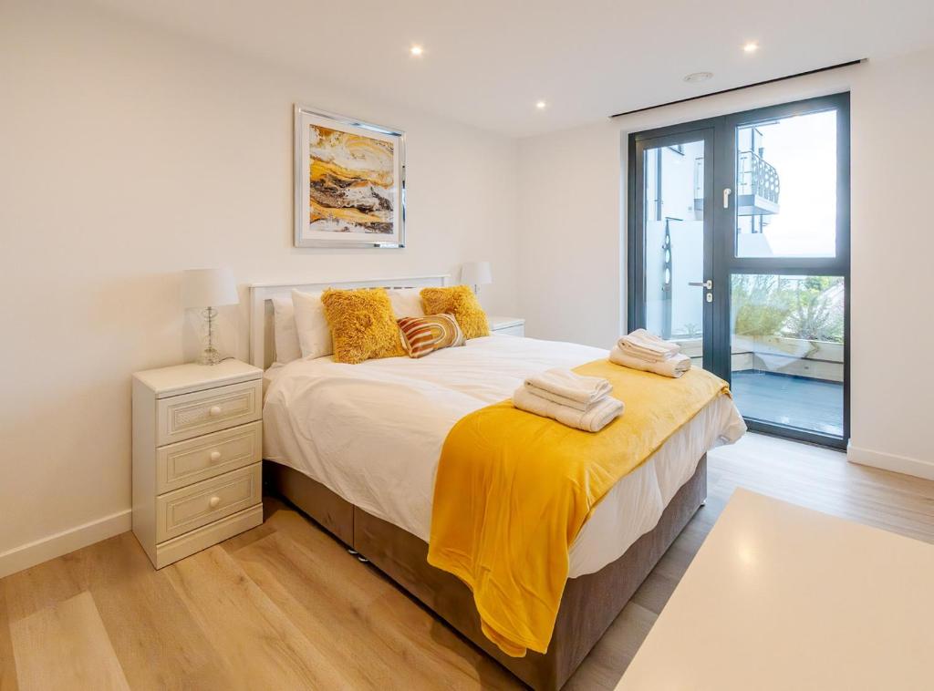 Un dormitorio con una cama con una manta amarilla. en SoHot Stays Sail Apt Sea Views Ground Floor Free Parking en Ramsgate