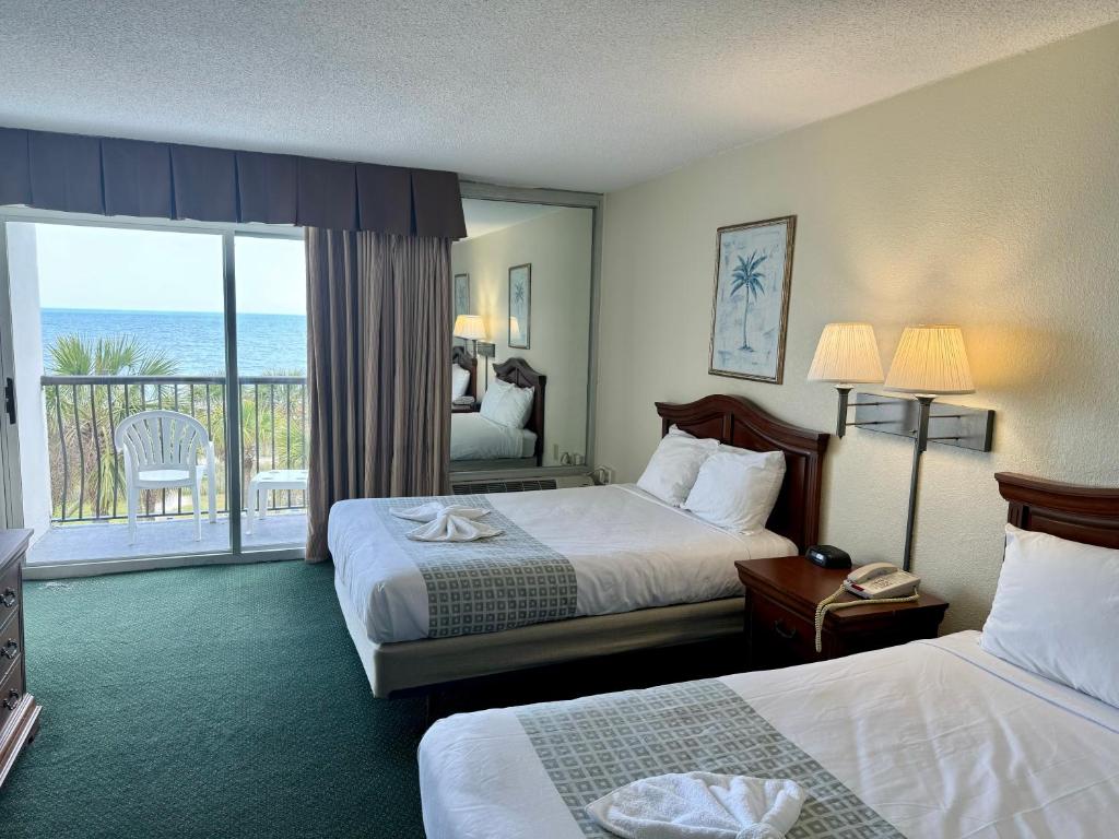 a hotel room with two beds and a balcony at Boardwalk Beach Resort in Myrtle Beach