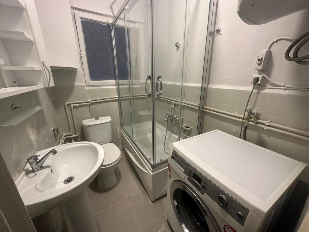 uma casa de banho com um lavatório e uma máquina de lavar roupa em sisly holiday 2 em Istambul