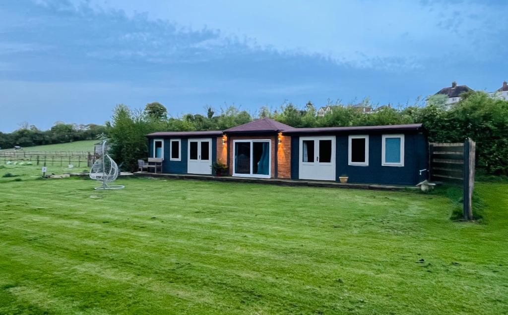 una casita en un campo con un patio en Gorgeous countryside cabin en Lyminge