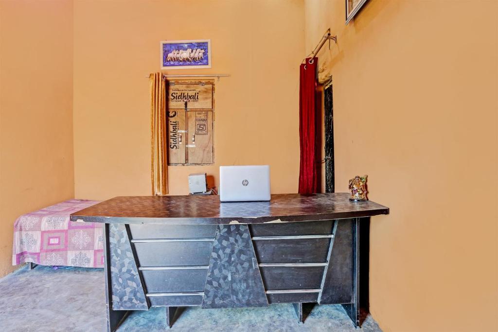een bureau in een kamer met een laptop bij Super OYO Unnati Farm And Resort in Nūrpur
