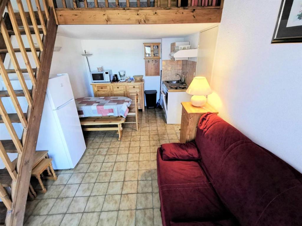 un salon avec un canapé rouge et une cuisine dans l'établissement Résidence Port Rose 2 - Appartement deux pièces mezzanine - 4 couchages PORT LEUCATE MAE-1681, à Leucate