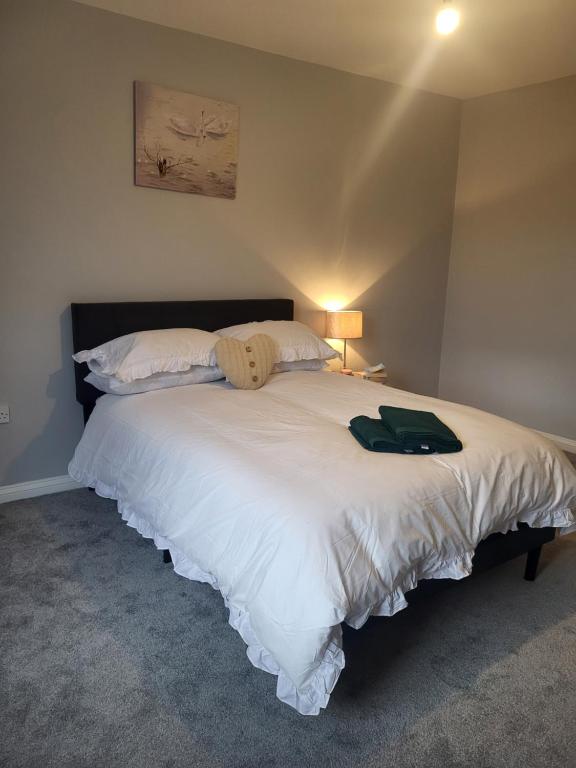- une chambre dotée d'un grand lit blanc avec une chemise verte dans l'établissement Cosy 2 Bedroom House, à Kent
