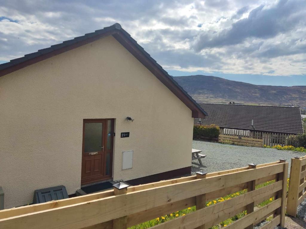 a small house with a wooden fence next to it at Self-catering in Portree in Portree