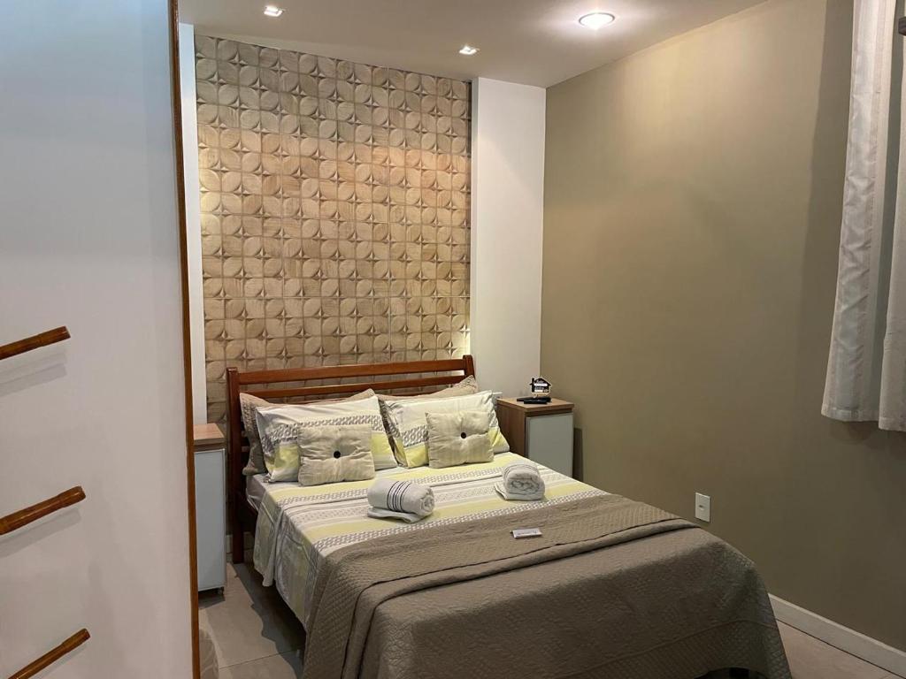 a bedroom with a bed with a large headboard at Hospedagem Sul de Minas Caxambu in Caxambu