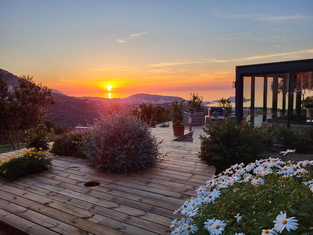 a sunset over a patio with flowers and a building at tre castelli in Monticello