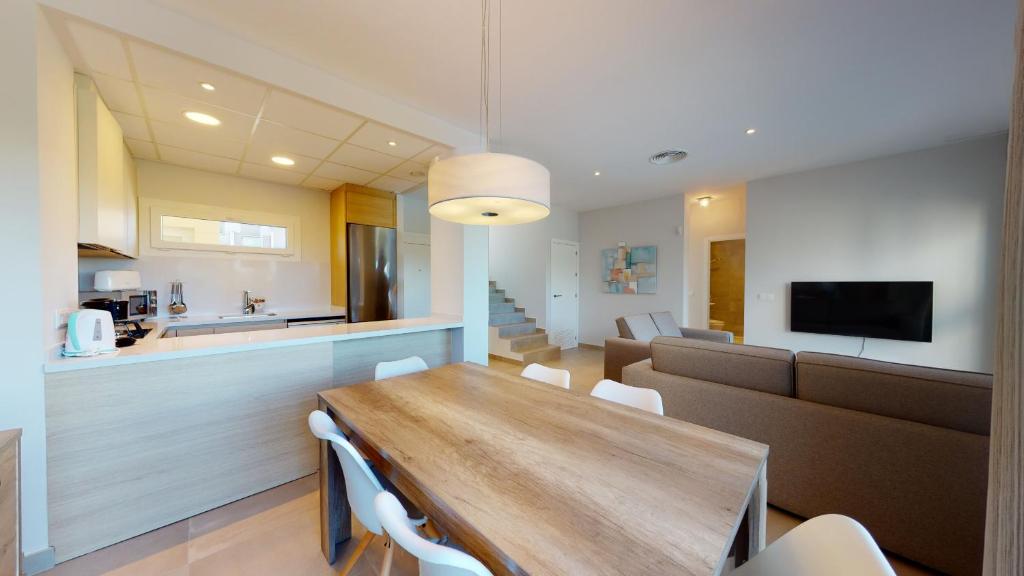 a dining room and kitchen with a wooden table and chairs at Souvenir by ON Travel in Oliva