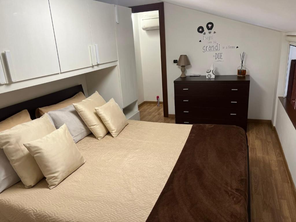 a bedroom with a large bed with pillows and a dresser at Petite maison in Fiumicino