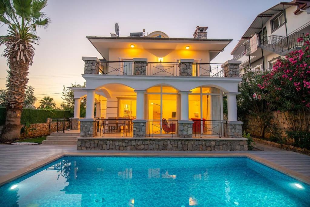 une maison avec une piscine en face d'une maison dans l'établissement Yosun villa harika tatil keyfi, à Fethiye