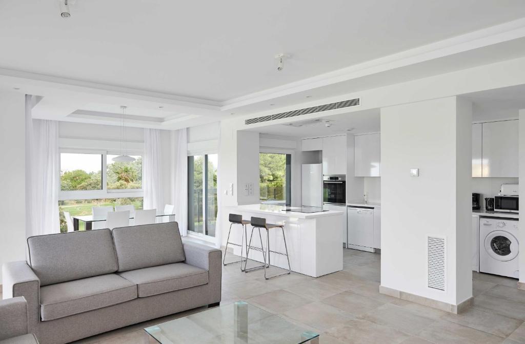 Una sala de estar con un sofá y una cocina. en Leafy by ON Travel, en Oliva