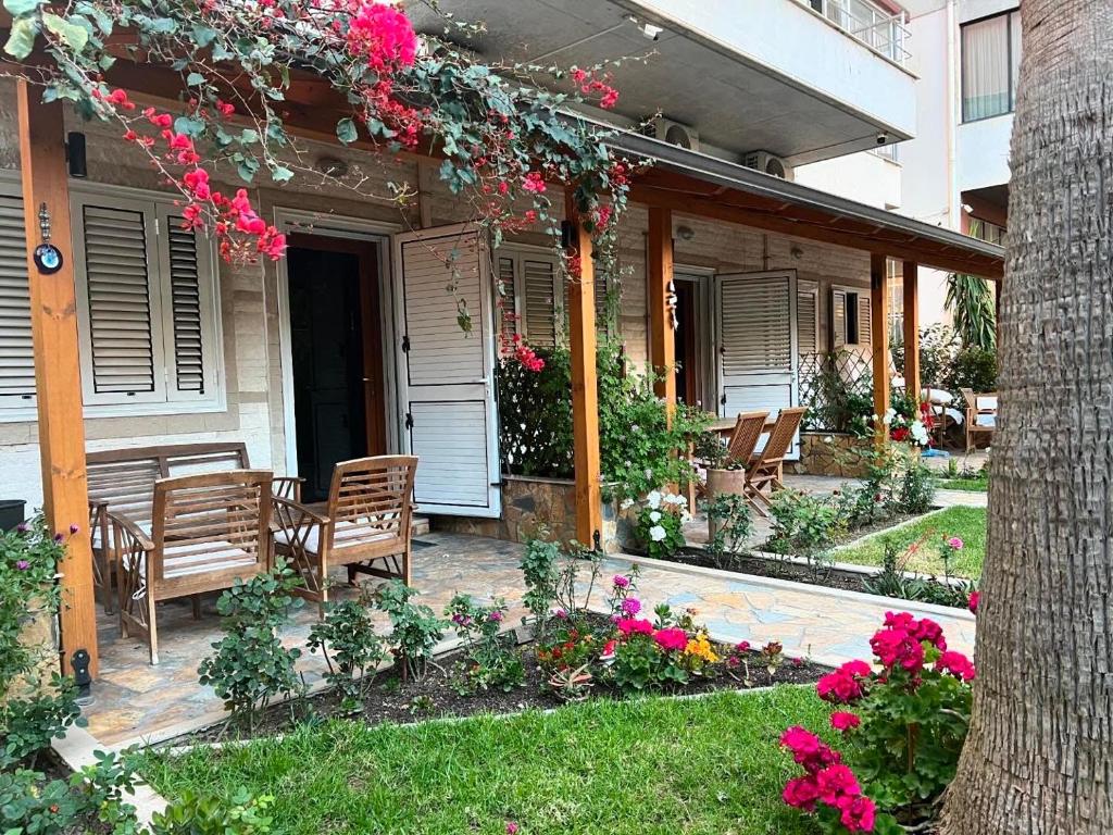 a house with a patio with chairs and flowers at Guest Room Angolo Toscano in Vlorë