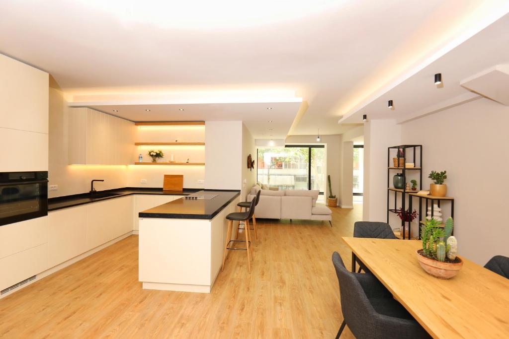 an open kitchen and living room with a table and chairs at Amantia Apartment in Vlorë