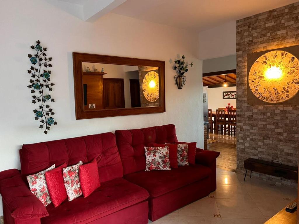 - un canapé rouge dans le salon avec cheminée dans l'établissement JPK Guest House, à Tiradentes