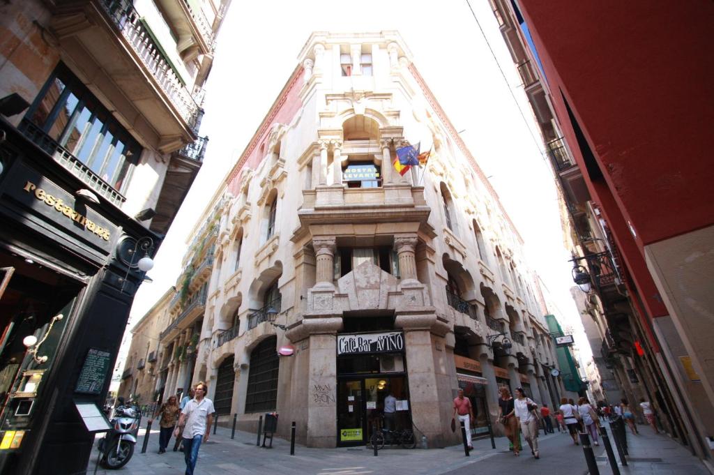 wysoki budynek z zegarem na boku w obiekcie Hostal Levante Barcelona w Barcelonie