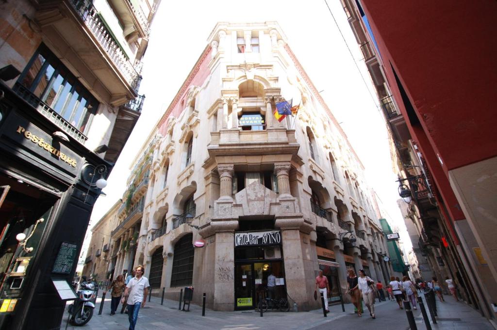 Un edificio alto con un reloj a un lado. en Hostal Levante Barcelona, en Barcelona