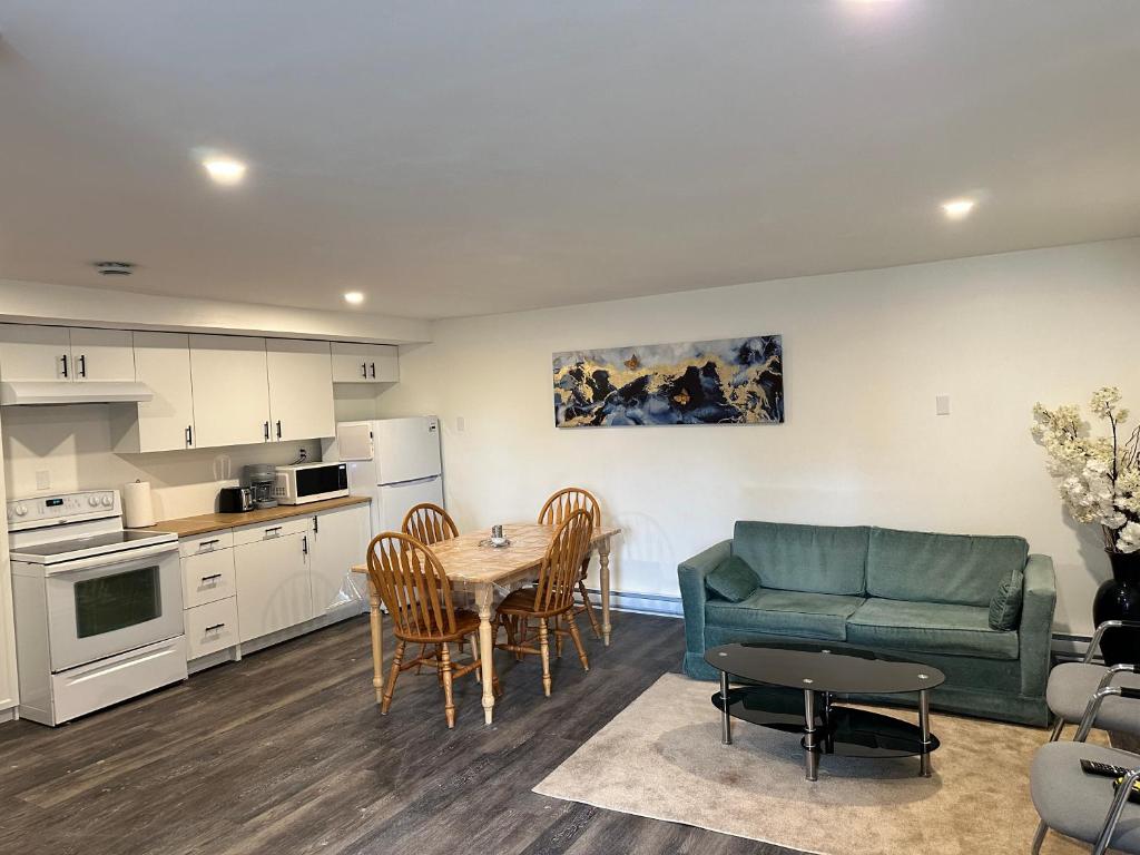 eine Küche und ein Wohnzimmer mit einem Tisch und einem Sofa in der Unterkunft Central Halifax one Bedroom apartment in Clayton Park in Halifax