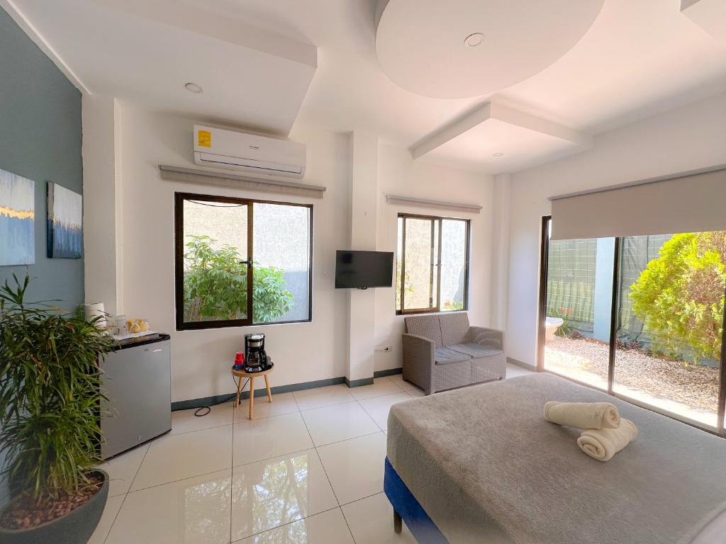 ein Schlafzimmer mit einem Bett und einem TV sowie einige Fenster in der Unterkunft Casa Garitas GuestHouse - Free SJO Airport Shuttle in Río Segundo