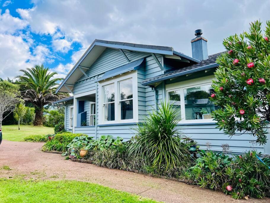 ein blaues Haus mit einem Weihnachtsbaum davor in der Unterkunft Rural paradise 30 mins from Auckland CBD in Auckland