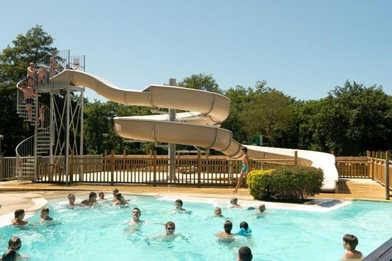 a group of people in a swimming pool with a slide at Mobilhome in Azur