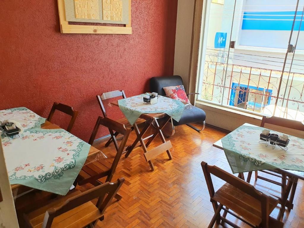 Pokój z 2 stołami i krzesłami oraz oknem w obiekcie CENTRALHE HOTEL w mieście Marília