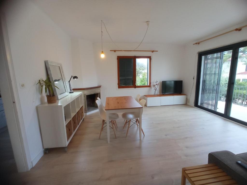een grote woonkamer met een tafel en stoelen bij Ca la Torreta in Torredembarra