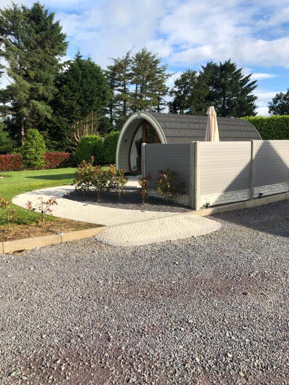 a garden with a fence and a house at Murphys Glamping Pod in Cork