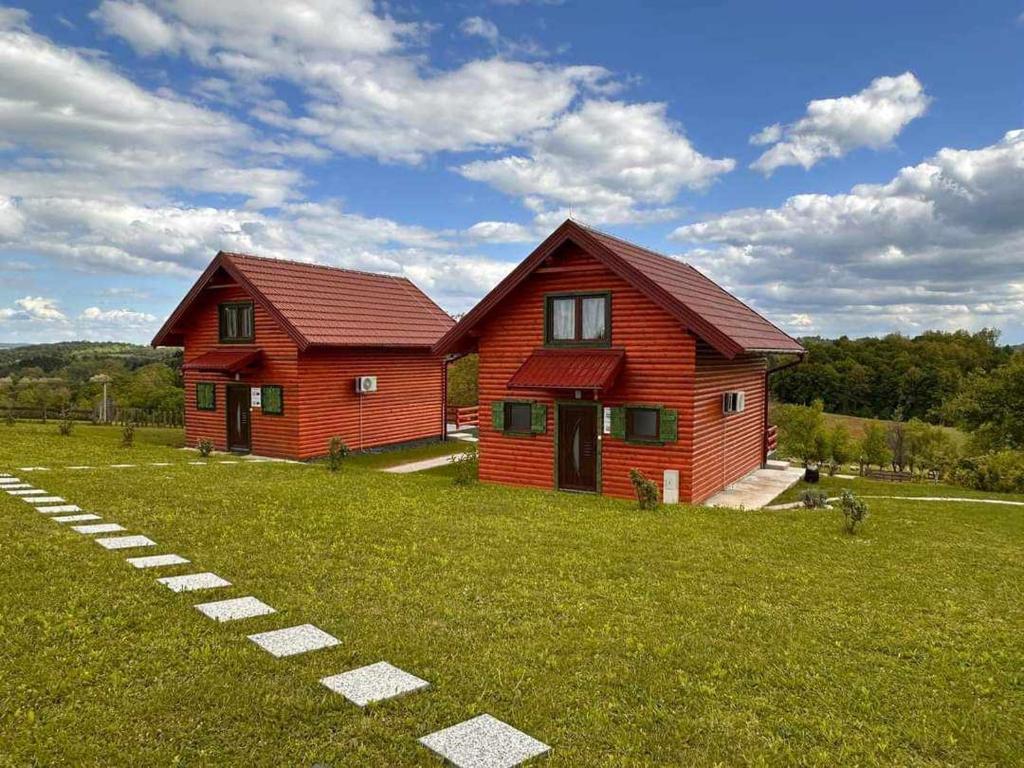 une maison rouge au milieu d'un champ dans l'établissement Resort Dudukovic, à Slunj