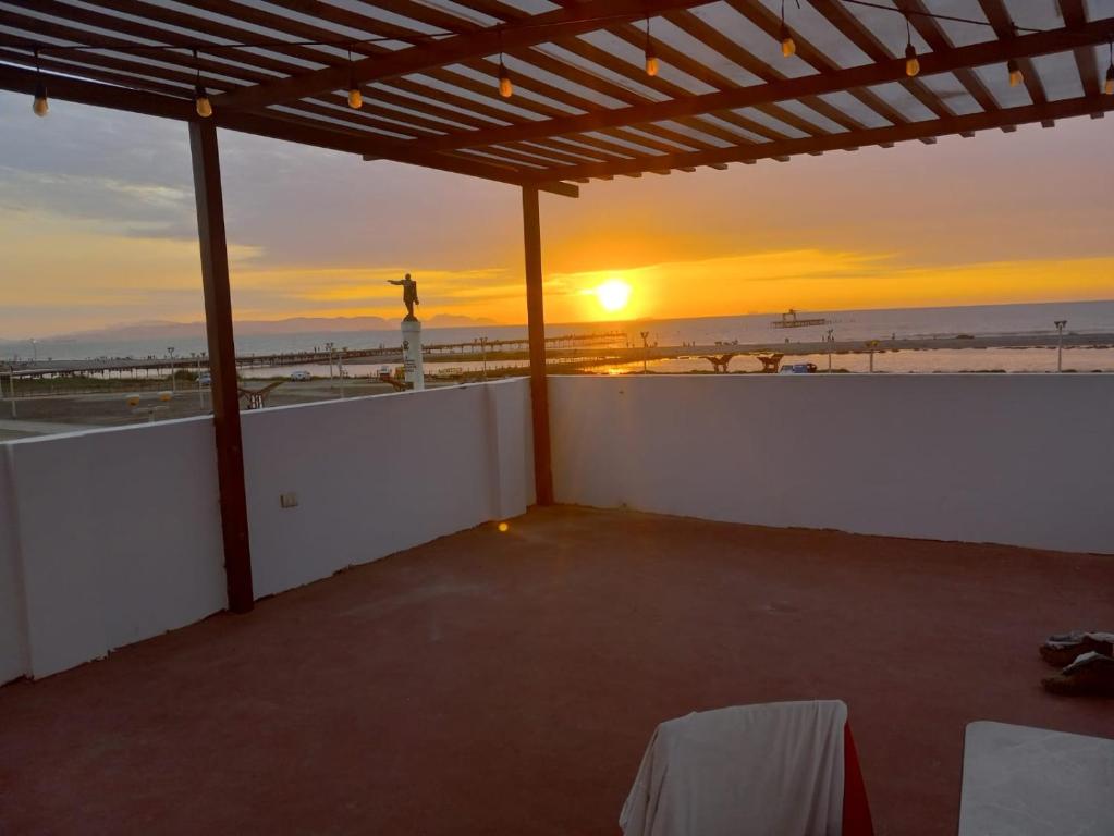 a view of the sunset from a patio with the beach at Hospedaje Pariwana in Pisco