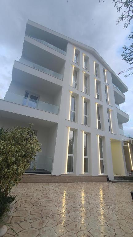 a large white building with a lot of windows at Hotel Blue Eyes in Vlorë
