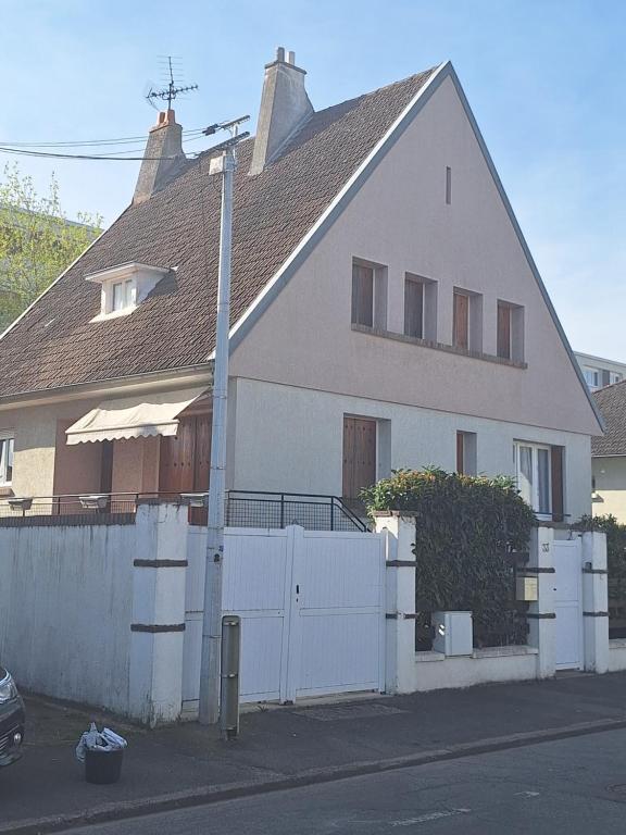 una casa blanca con una valla delante en L'Arche de Yves-Jody, en Saint-Jean-de-Braye