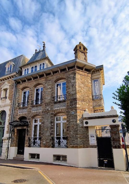 un bâtiment en pierre avec une cheminée au-dessus dans l'établissement Appartement 1 Maison Dior, centre, plage à 500 m, à Granville
