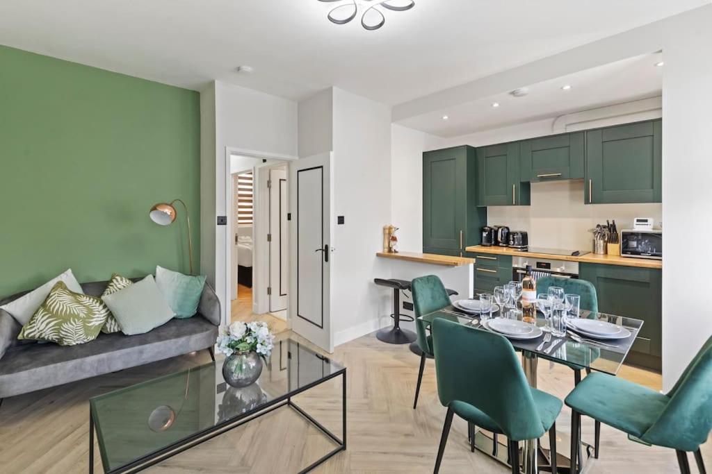 ein Wohnzimmer mit einem Tisch und grünen Schränken in der Unterkunft High Spec Luxury Flat in Battersea in London