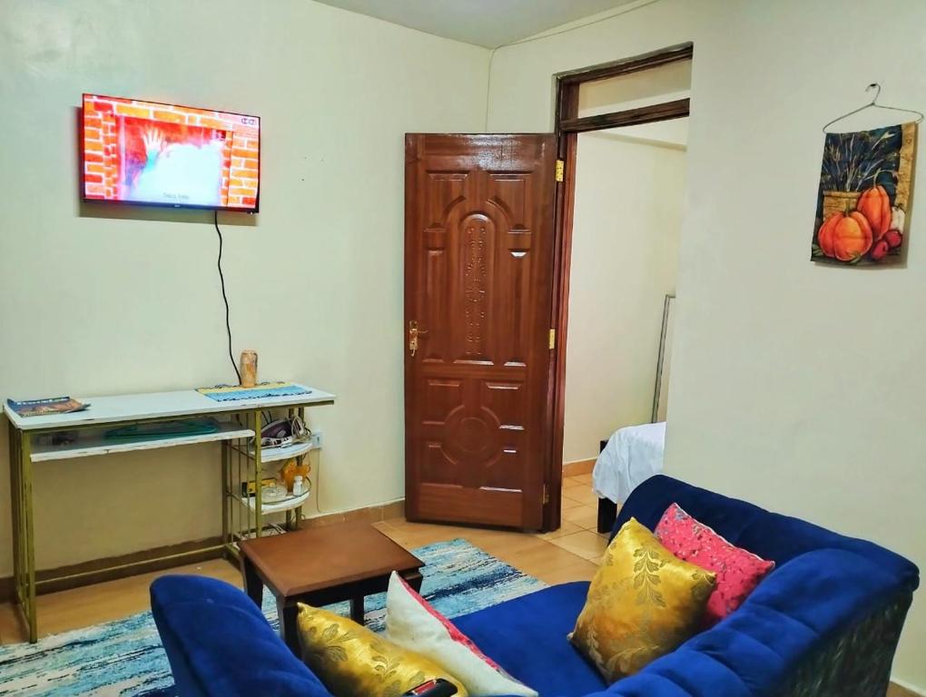 een woonkamer met een blauwe bank en een kast bij Tamara studio bedsitter, Nyanchwa Kisii in Kisii