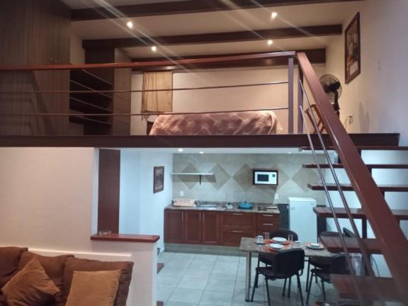 salon z łóżkiem na podwyższeniu i kuchnią w obiekcie SUITE MISION JURIQUILLA #1 w mieście Juriquilla