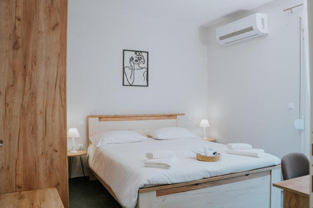 a bedroom with a large bed with white sheets at Pamvotis Urban Suites in Ioannina