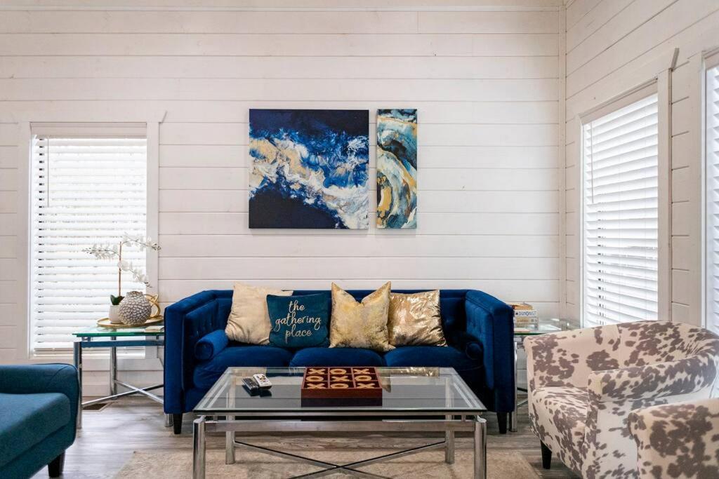 uma sala de estar com um sofá azul e uma mesa em Diamond Cabin w/ jet shower & secluded back deck! em Broken Bow
