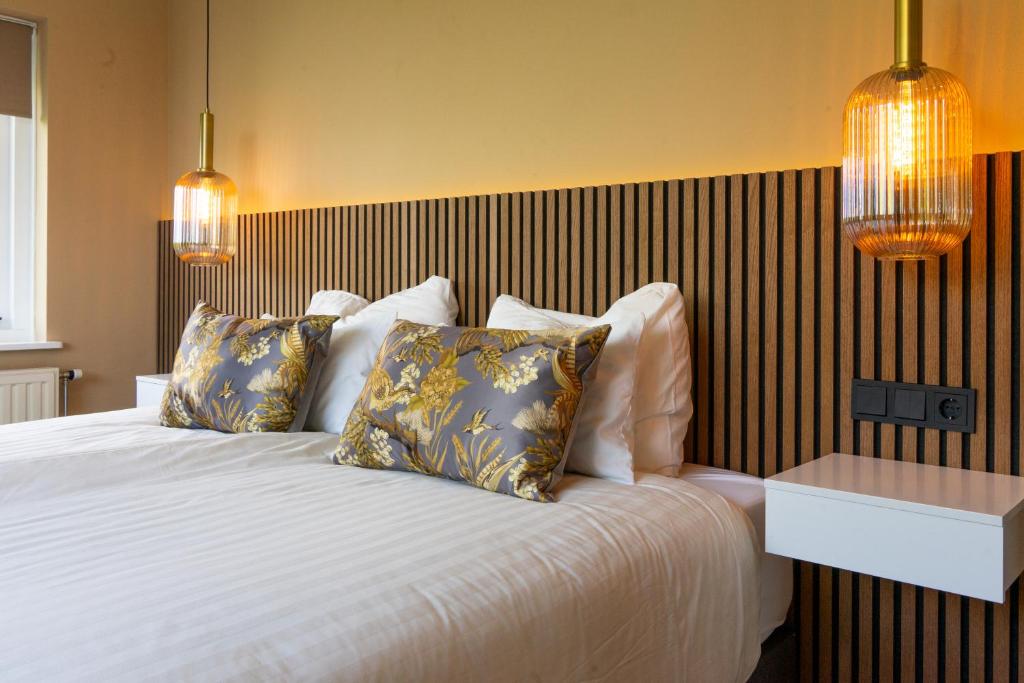 ein Schlafzimmer mit einem großen weißen Bett mit Kissen in der Unterkunft B&B Dijkhuis in Vrouwenpolder