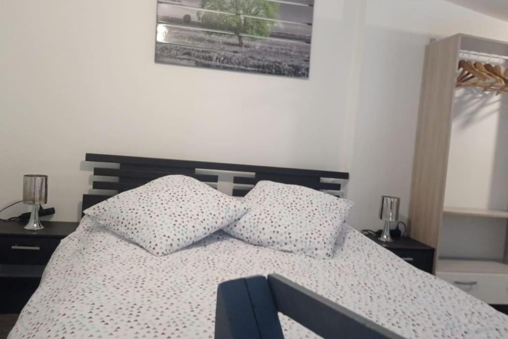 a bedroom with a bed with two pillows on it at Appartement coeur de ville! in Foix