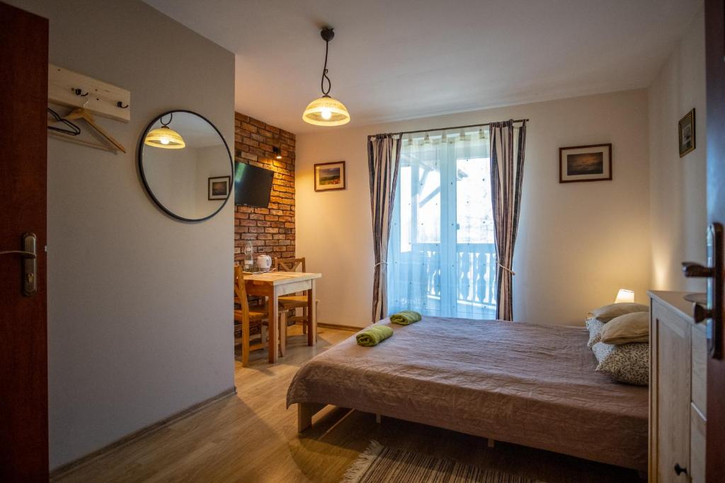 een slaapkamer met een bed, een spiegel en een tafel bij Siedlisko Leszczewek in Leszczewek