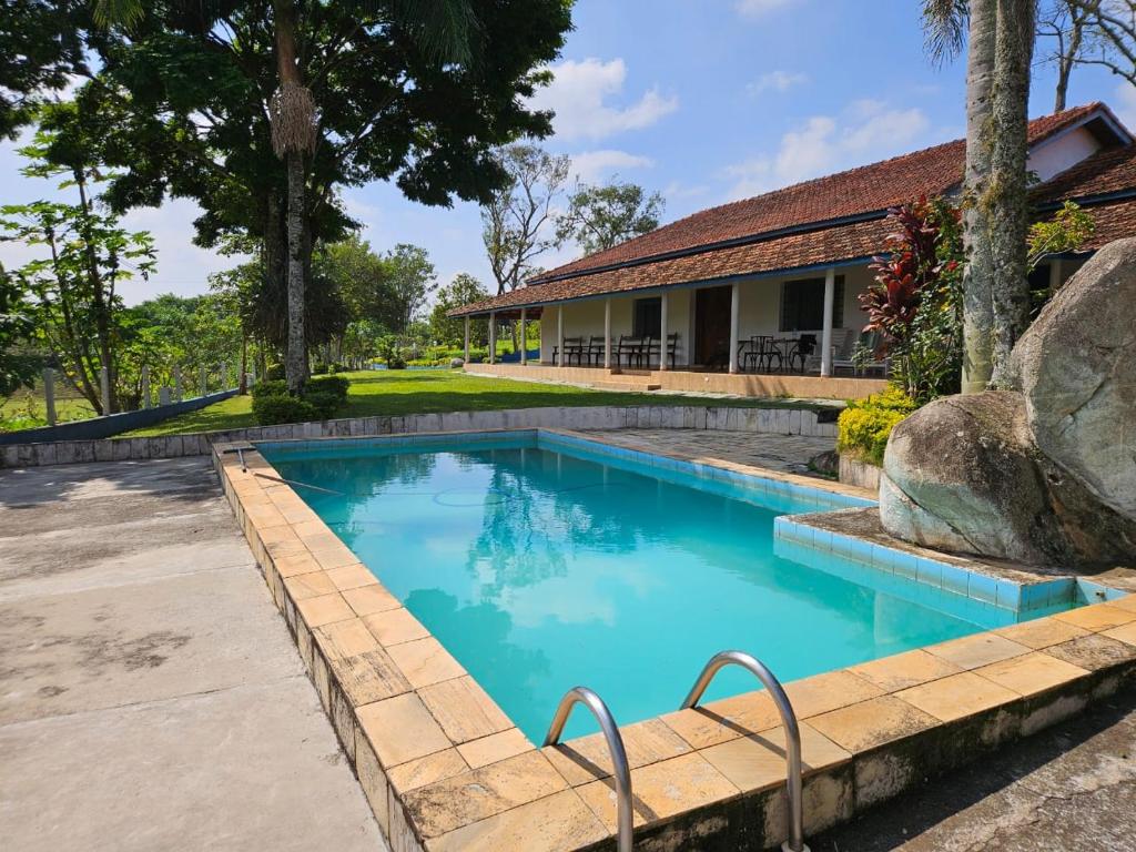 a swimming pool in a yard with a house at Sítio Santa Filomena - São Roque in São Paulo