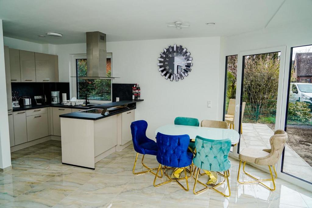 une cuisine avec des chaises bleues et une table blanche dans l'établissement Dream Holiday Haus D für 6 Personen, à Tornesch