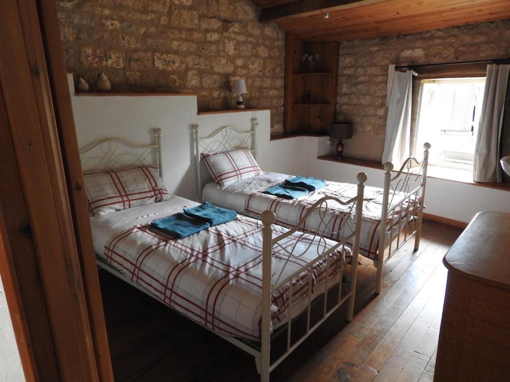a bedroom with two beds and a window at La maison de Léon in Celles-sur-Belle