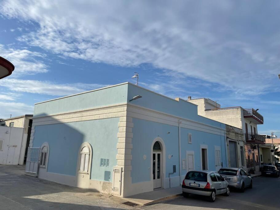 een blauw gebouw met auto's voor het gebouw bij Casa storica in Montalbano