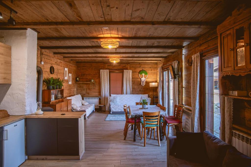cocina y sala de estar con mesa y sillas en Czarna Owca, en Zalesie