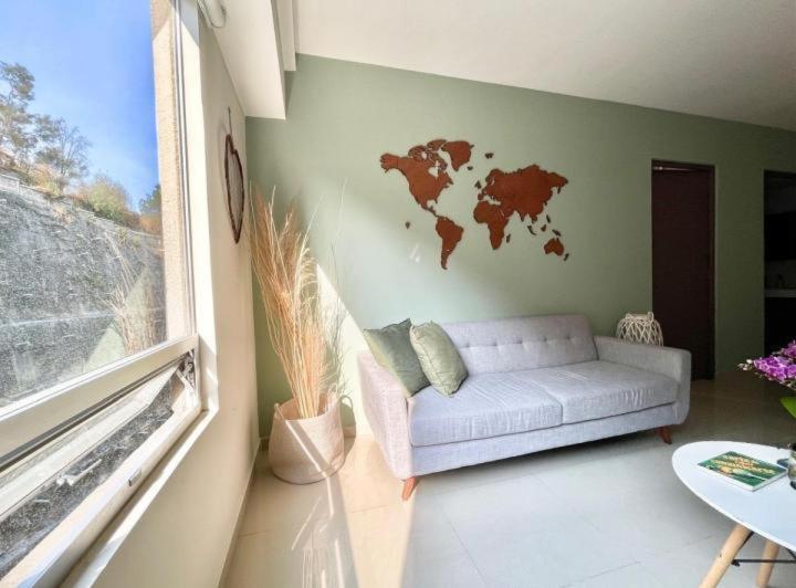 sala de estar con sofá y mapa en la pared en Departamento equipado en Santa Fe con servicio shuttle por la zona en Ciudad de México
